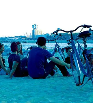 grupo de jovenes en bicicleta playa barcelona